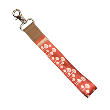 Load image into Gallery viewer, Orange wristlet keychain with white mushrooms on it