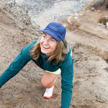 Load image into Gallery viewer, women climbing a mountain wearing a navy Wild Rye quick-dry hat