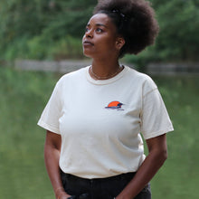 Load image into Gallery viewer, Woman wearing tan loon t-shirt. Has loon and sunset on front left side.
