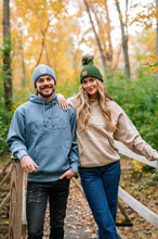 Load image into Gallery viewer, Man and woman wearing Sota embroidered sweatshirts in blue and tan