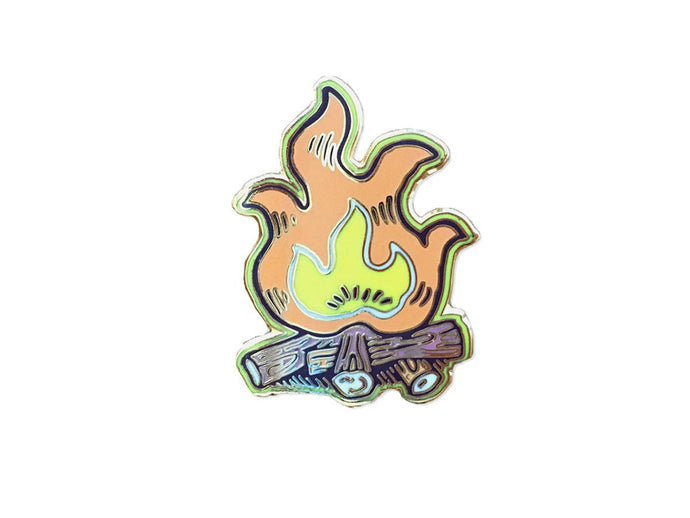 Enamel pin featuring campfire and logs
