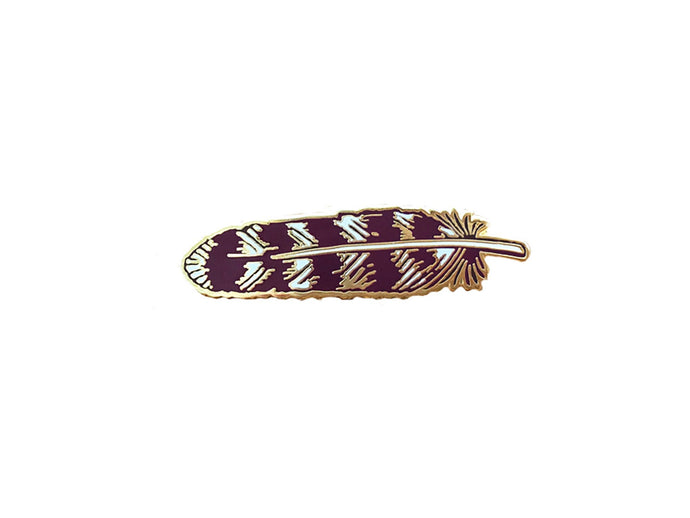 Gold and maroon pin that looks like a feather