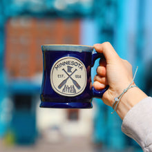 Load image into Gallery viewer, Blue Minnesota mug that has trees and canoe paddles
