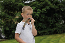 Load image into Gallery viewer, kid blowing whistle on survival bracelet
