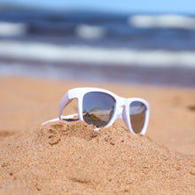 Load image into Gallery viewer, White youth sunglasses in the sand at the beach
