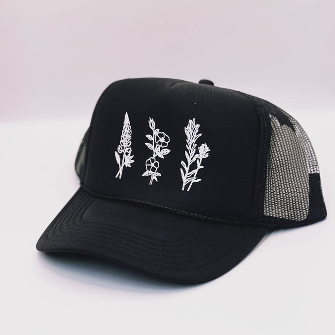 Black mesh hat with three white wildfowers on the front