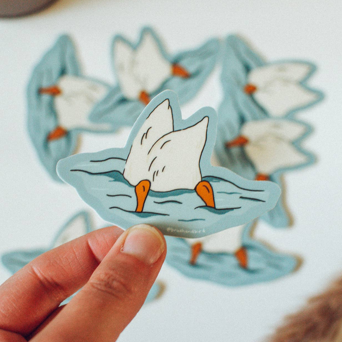 Sticker of a duck diving into water with its butt in the air