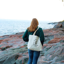 Load image into Gallery viewer, Girl walking along a rocky lake with a Minnesota tote bag over her shoulder
