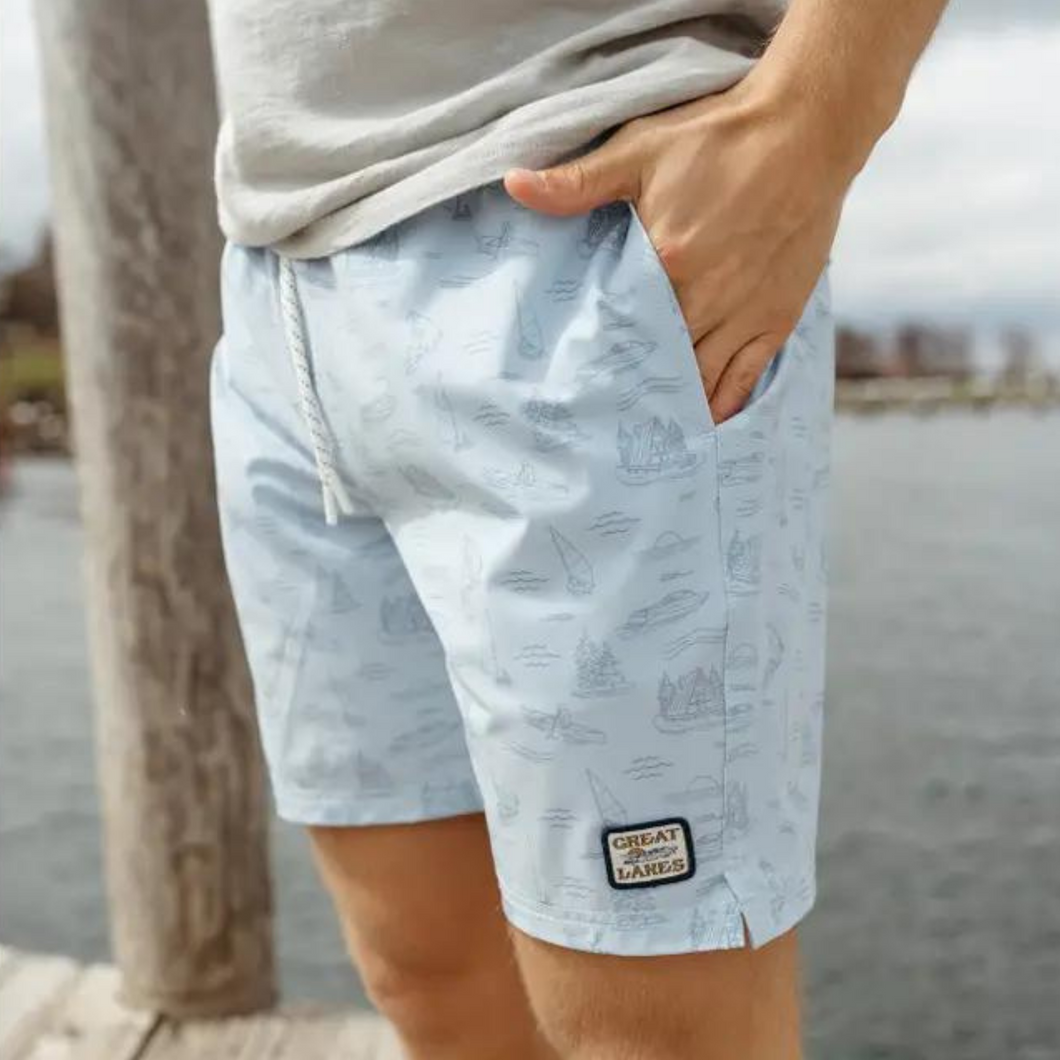 Men's blue sailboat swim trunk with hand in pocket