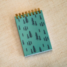 Load image into Gallery viewer, Small pocket notebook with green front and dark green trees on it
