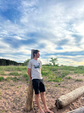 Load image into Gallery viewer, Man standing on beach wearing trees and cloud t-shirt
