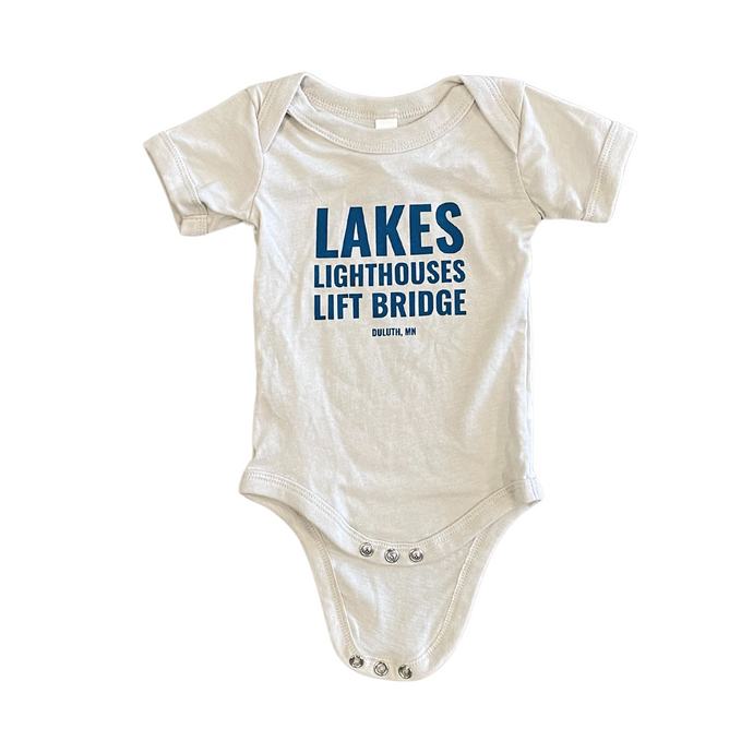 Onesie that says Lakes Lighthouses Lift Bridge Duluth, MN in blue writing