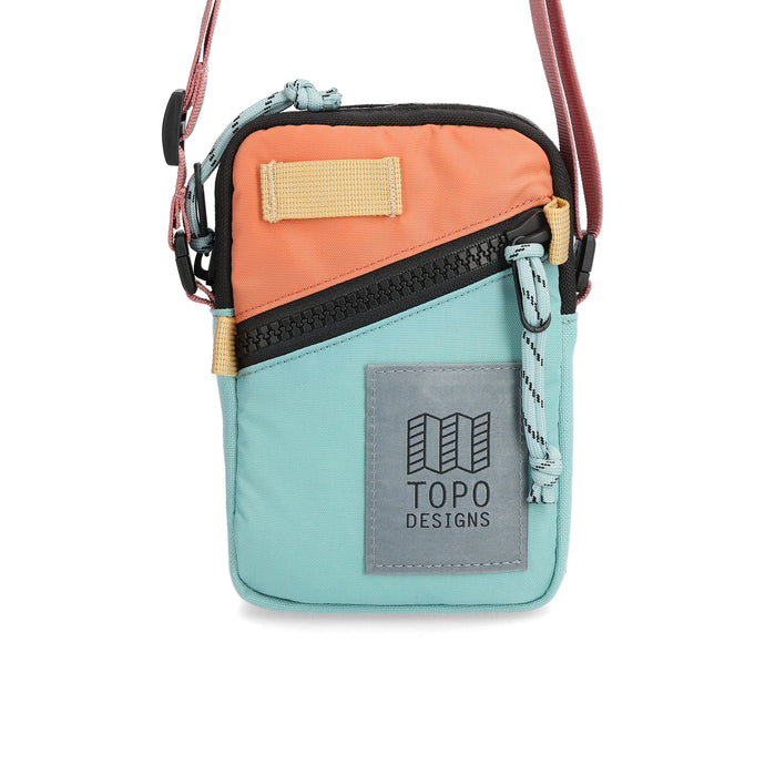 Small bag with shoulder strap. Bag is peach and light blue with a zipper diagnally across front and over top