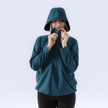 Load image into Gallery viewer, Woman wearing teal windbreaker with hood up and zipping it up
