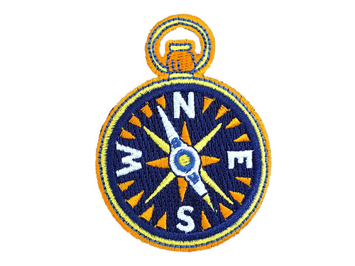 Patch that looks like a compass. Compass is blue, yellow and orange