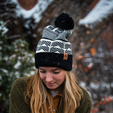Load image into Gallery viewer, Person wearing a black and white patterned beanie in a snowy outdoor setting
