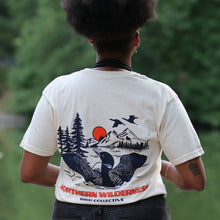 Load image into Gallery viewer, model wearing loon tshirt. Back of shirt showing Loon spreading it&#39;s wings in front of mountain scenery
