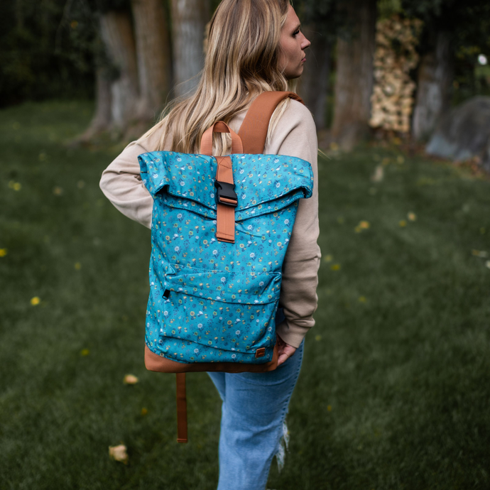 Person wearing a blue floral-patterned backpack in an outdoor setting